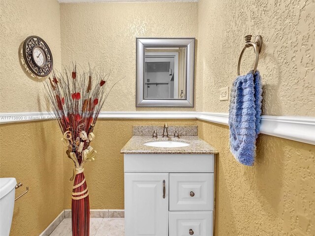 bathroom featuring tile patterned flooring, vanity, and toilet