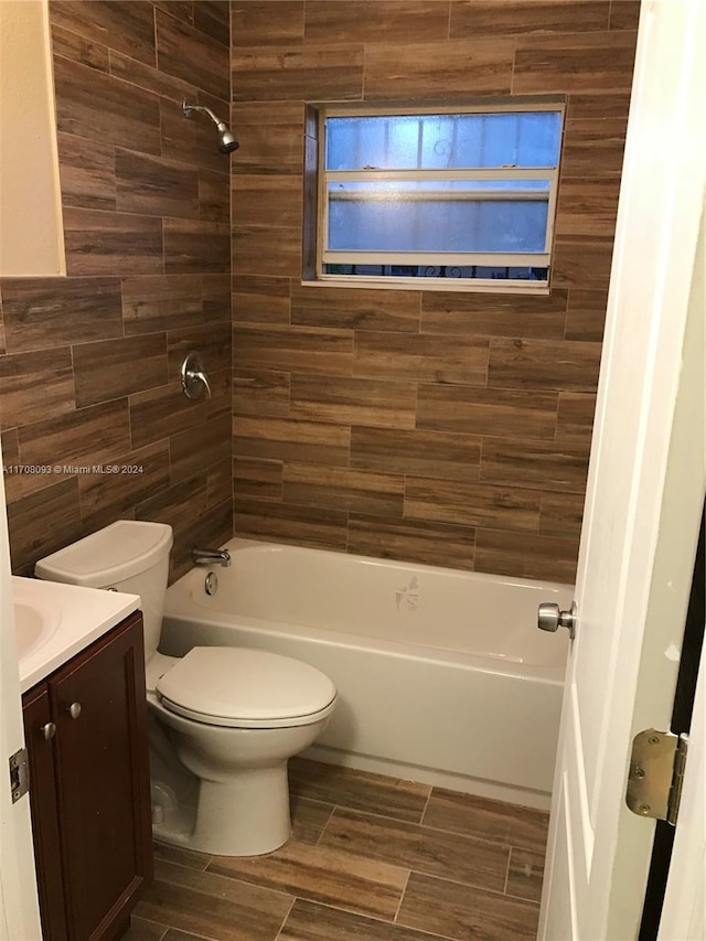 full bathroom with vanity, tiled shower / bath combo, and toilet