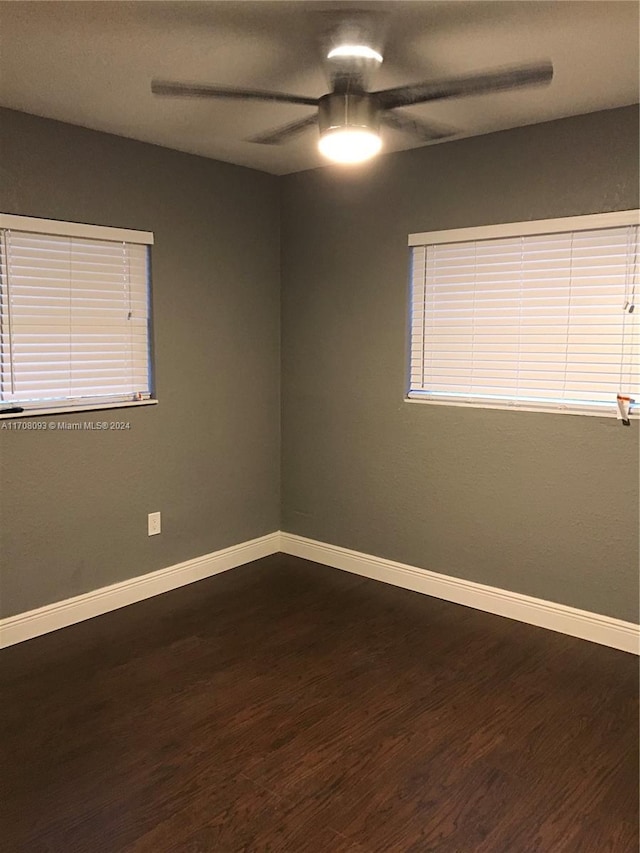 unfurnished room featuring ceiling fan and dark wood-type flooring