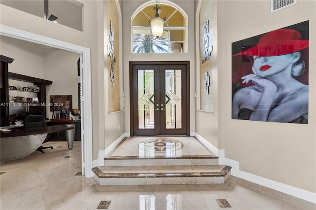 foyer with a towering ceiling and french doors