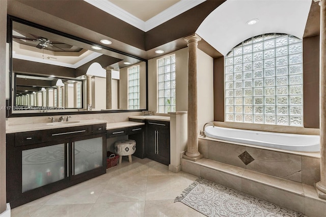 bathroom with tiled bath, ornate columns, vanity, and ornamental molding