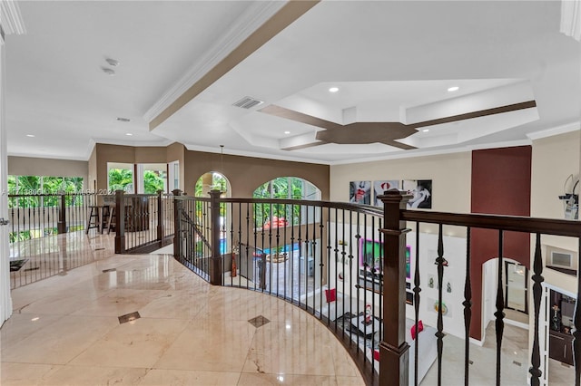 corridor featuring a tray ceiling and ornamental molding