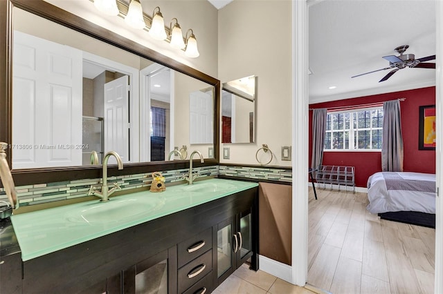 bathroom featuring vanity, tasteful backsplash, ceiling fan, and ornamental molding