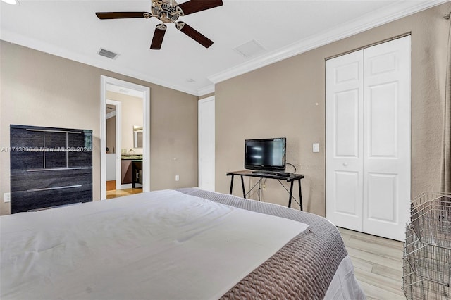 bedroom featuring ensuite bath, ceiling fan, light hardwood / wood-style flooring, crown molding, and a closet