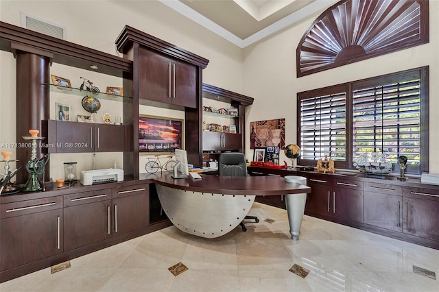 office area featuring a towering ceiling and crown molding