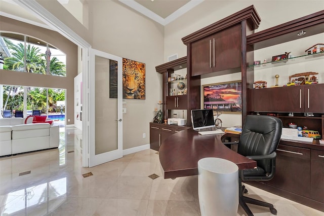 office featuring a towering ceiling, ornamental molding, and french doors