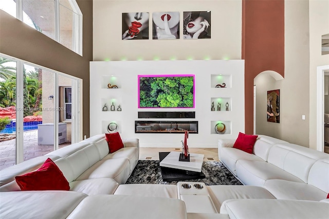 living room with a towering ceiling and built in features