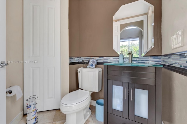 bathroom with toilet, vanity, tasteful backsplash, and tile patterned floors