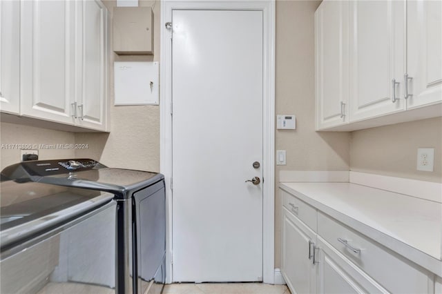 washroom with washer and dryer and cabinets