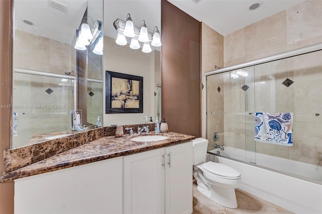 full bathroom featuring tile patterned floors, vanity, toilet, and enclosed tub / shower combo