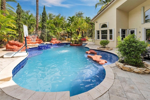 view of swimming pool with pool water feature and a patio