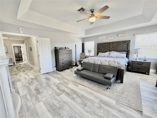 corridor with a textured ceiling, light wood-type flooring, and plenty of natural light