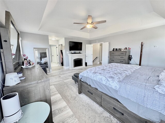 bedroom featuring a closet, light wood-type flooring, ceiling fan, ornamental molding, and a textured ceiling