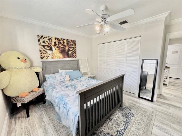 bedroom featuring a closet, ceiling fan, ornamental molding, a textured ceiling, and light hardwood / wood-style flooring