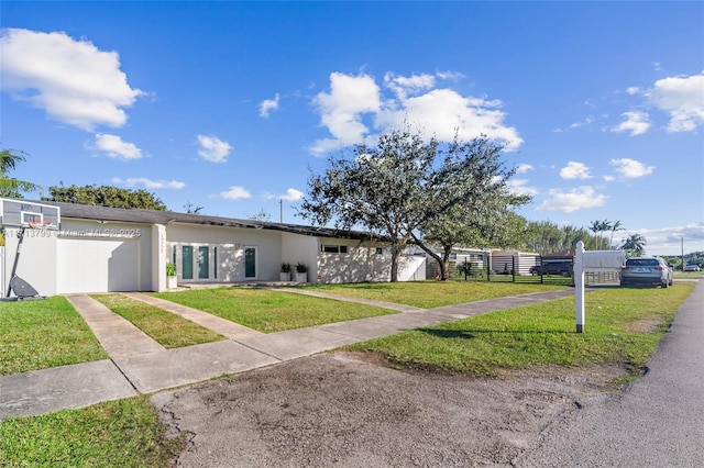 ranch-style home featuring a garage and a front lawn