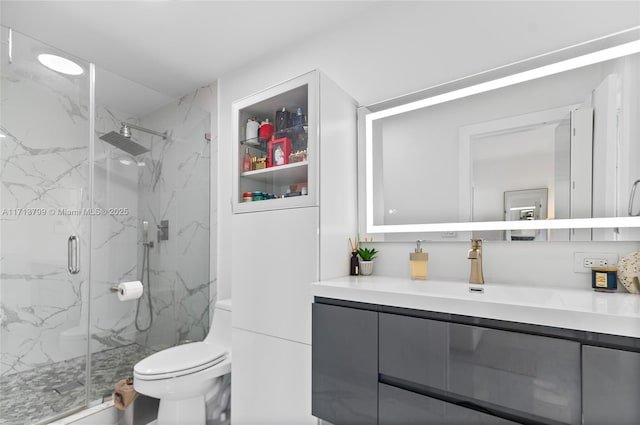 bathroom with vanity, toilet, and a shower with shower door