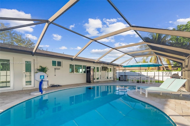 view of swimming pool featuring a lanai and a patio area