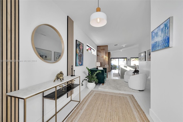 hallway featuring lofted ceiling and light tile patterned floors