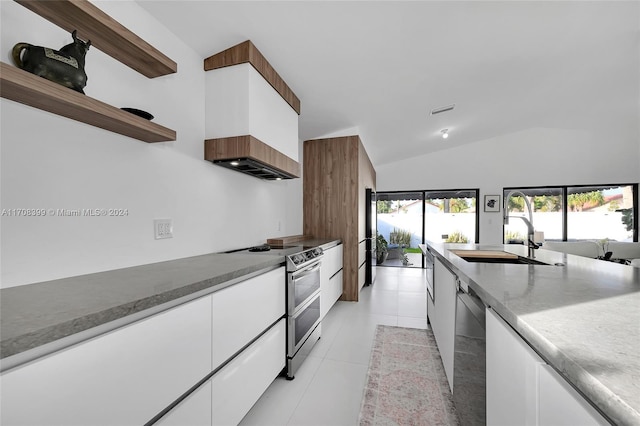 kitchen with premium range hood, sink, light tile patterned floors, appliances with stainless steel finishes, and white cabinetry