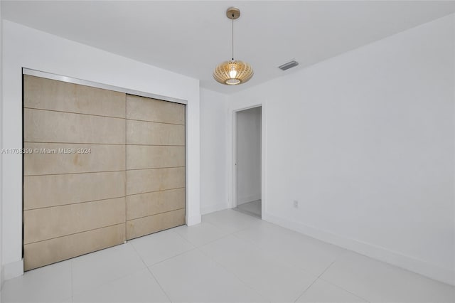 unfurnished bedroom with light tile patterned floors and a closet