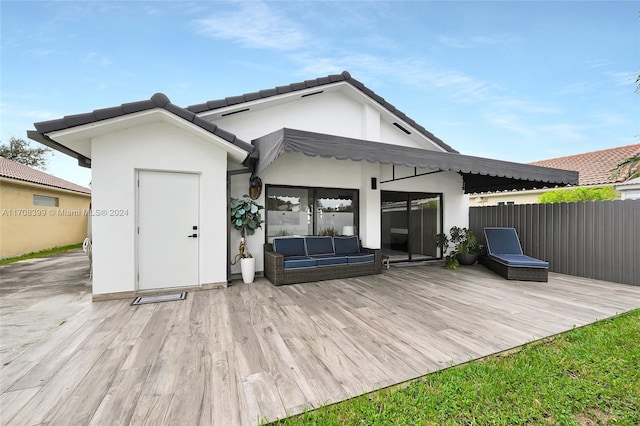 rear view of house with a wooden deck and an outdoor living space