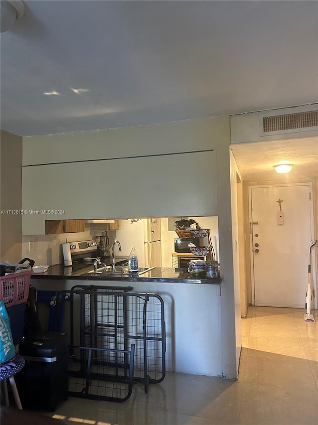 kitchen featuring tile patterned flooring, white fridge, and sink