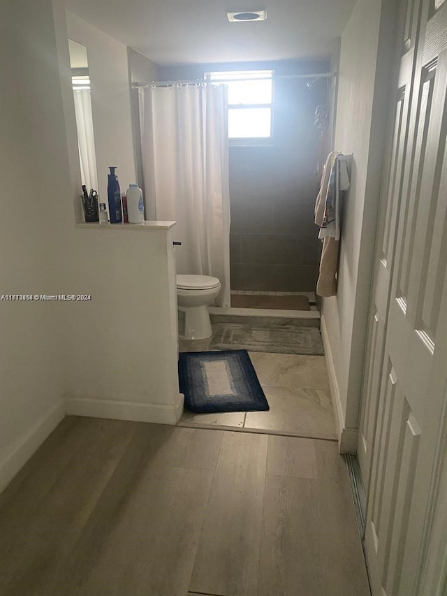 bathroom featuring a shower with curtain and toilet