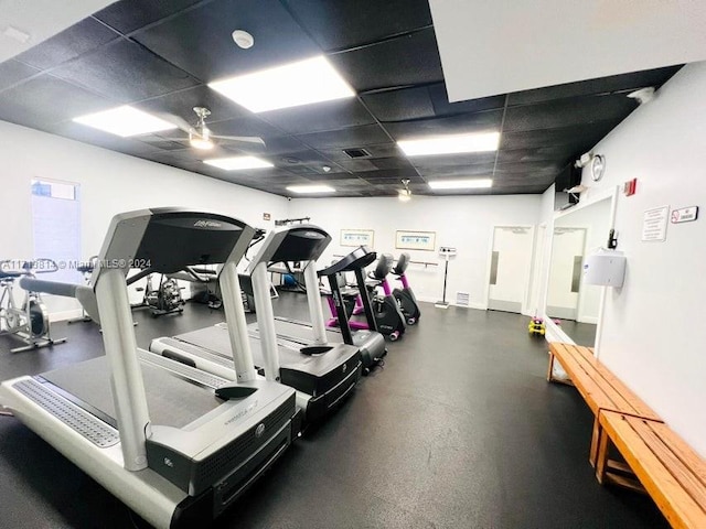 workout area with a drop ceiling and ceiling fan