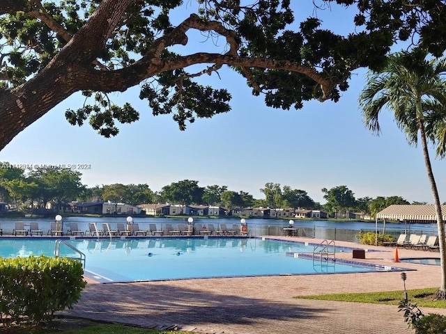 view of swimming pool with a water view and a patio