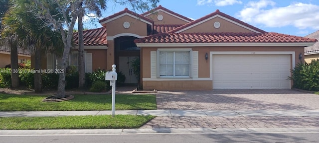 view of front of house featuring a garage and a front lawn