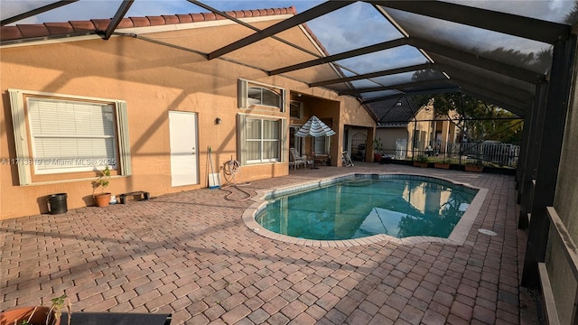 view of swimming pool featuring a patio area and a lanai