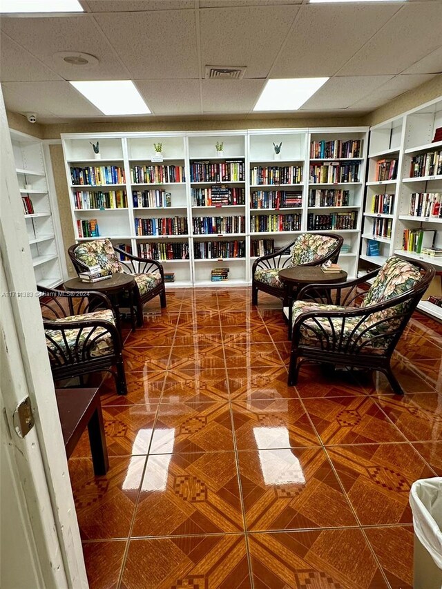 living area featuring a paneled ceiling