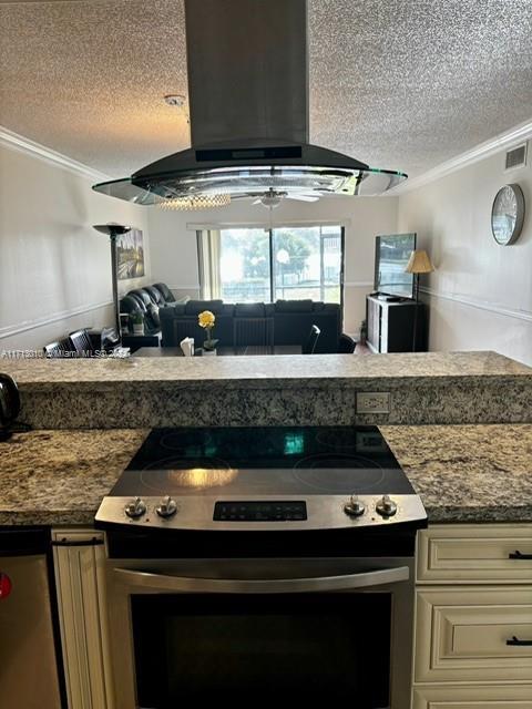 kitchen featuring stainless steel electric stove, island range hood, ornamental molding, and a textured ceiling