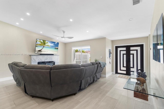 living room with ceiling fan and a premium fireplace