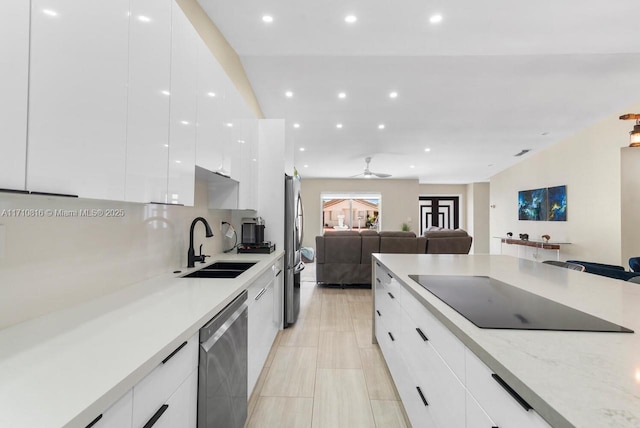 kitchen with white cabinetry, sink, ceiling fan, light stone counters, and stainless steel appliances