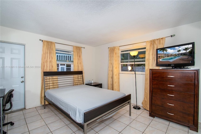 bedroom with light tile patterned floors and a textured ceiling