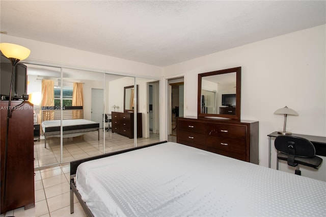 bedroom with light tile patterned floors and a closet