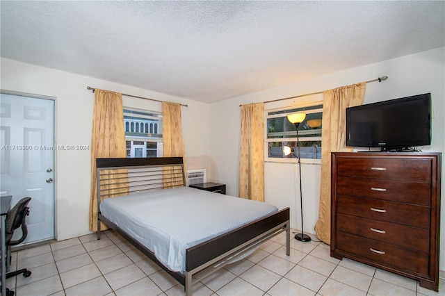 bedroom with light tile patterned floors and a textured ceiling