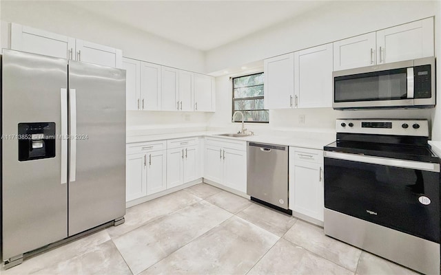 kitchen with white cabinets, light tile patterned flooring, sink, and appliances with stainless steel finishes