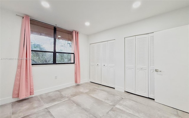 unfurnished bedroom featuring multiple closets