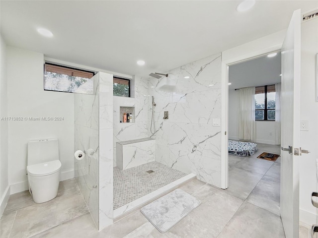 bathroom with toilet and a tile shower