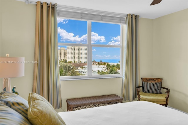 bedroom featuring ceiling fan and a water view