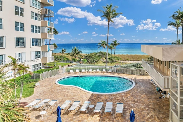 view of swimming pool with a patio area and a water view