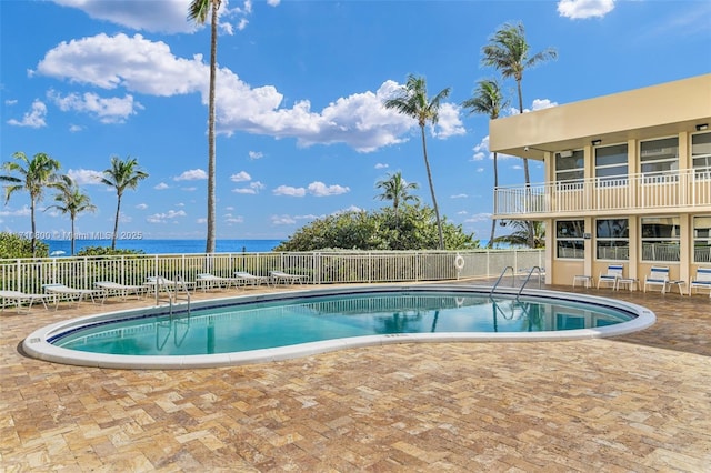 view of pool with a patio and a water view