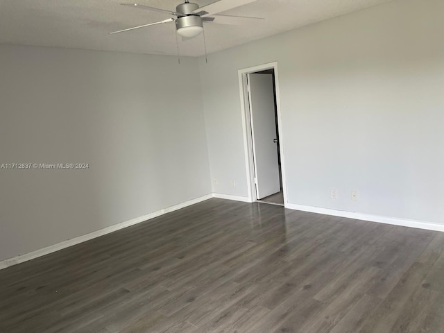 empty room featuring ceiling fan, dark hardwood / wood-style floors, and a textured ceiling