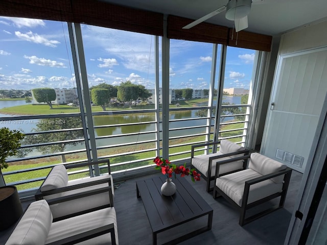 sunroom / solarium featuring ceiling fan, a healthy amount of sunlight, and a water view