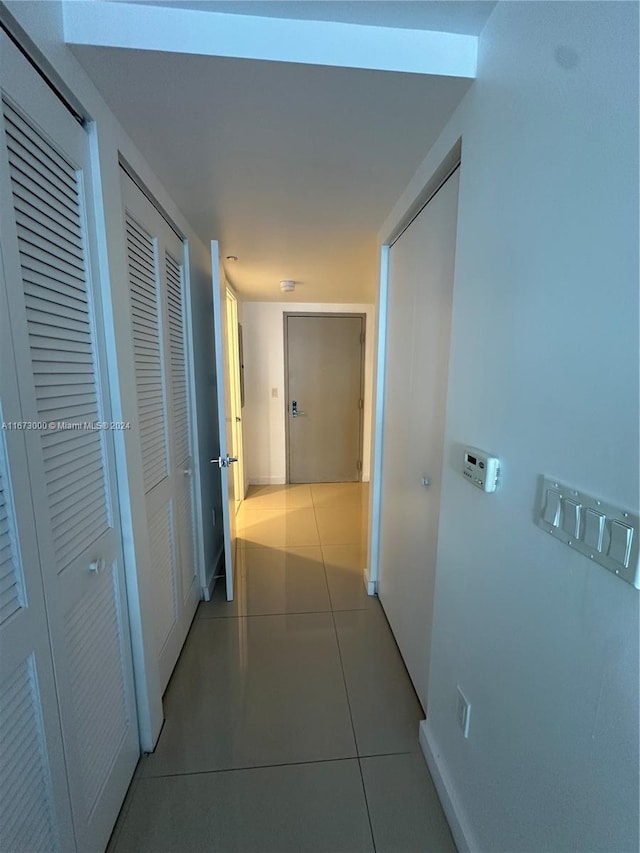 hallway with tile patterned flooring