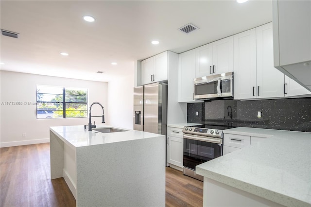 kitchen with white cabinets, appliances with stainless steel finishes, decorative backsplash, and sink