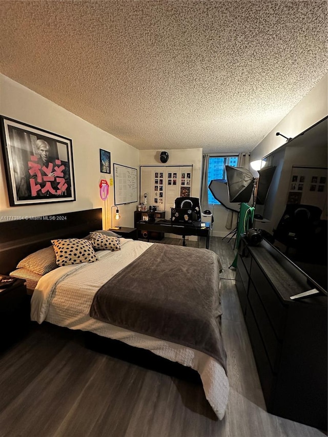 bedroom with hardwood / wood-style floors and a textured ceiling