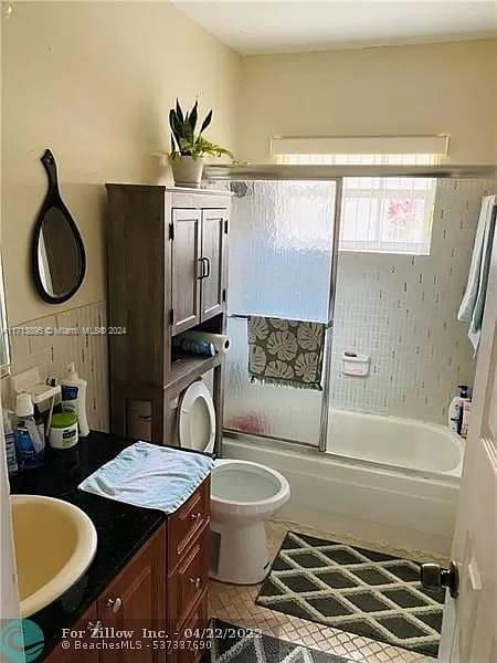 full bathroom with tile patterned floors, vanity, toilet, and combined bath / shower with glass door